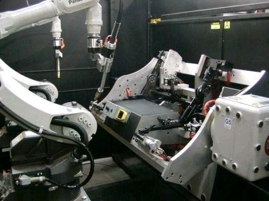 Robotic MIG welding cell working on an automotive assembly