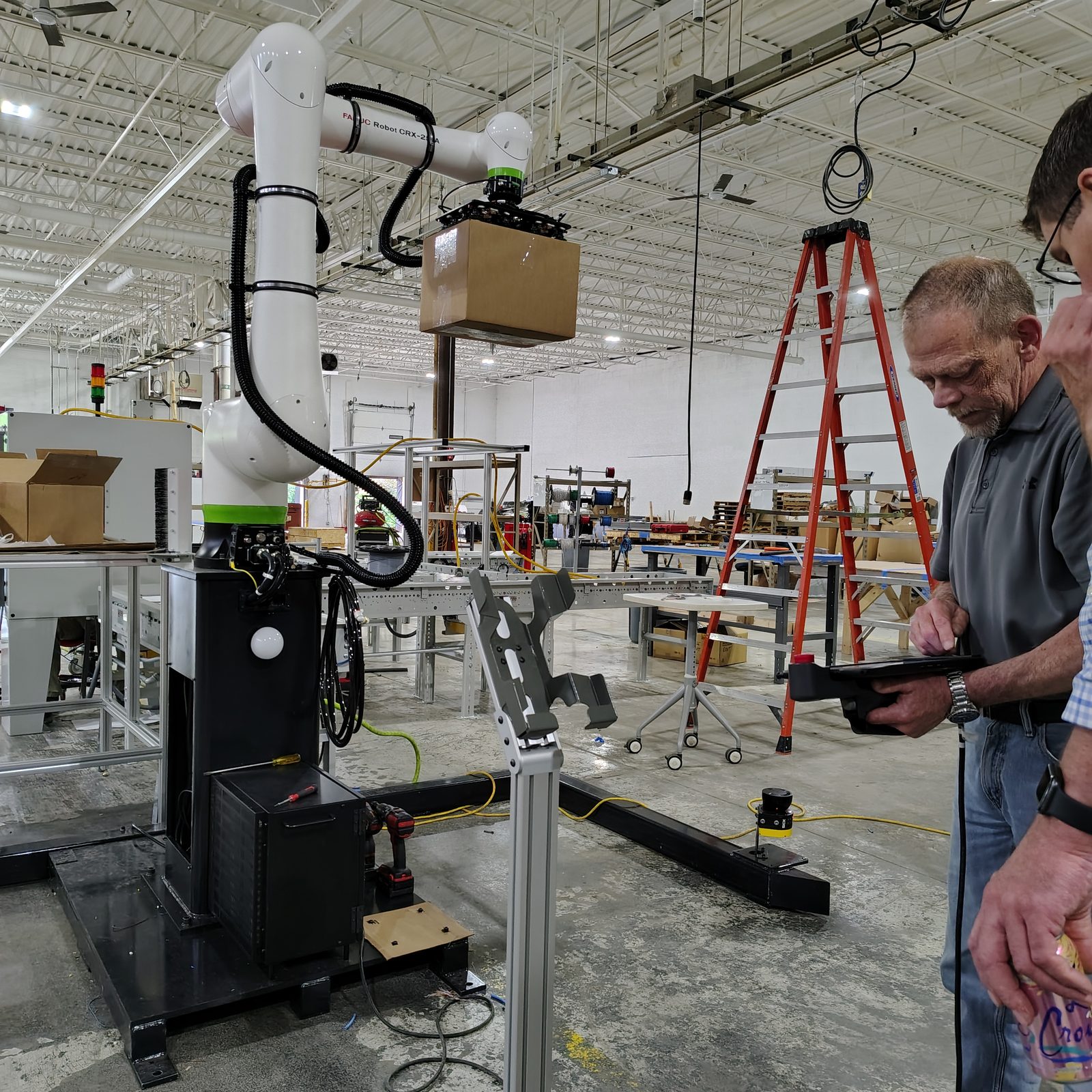 Technicians working on machine wiring and tooling on site